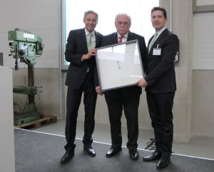 Die Geschäftsführer Julian Utz und Jürgen Rehmann übernahmen den Schlüssel für das neue Fabrikgebäude von Architekt Manfred Himpel. (Abb.: Wolff)