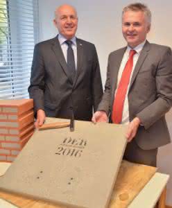 Übergabe des ersten Exemplars an den bayerischen BauInnungspräsidenten Franz- Xaver Peteranderl (l.) durch Stiftungsgründer Johannes Edmüller. Die Hülle aus Beton musste zuerst mit einem fachgerechten Hammerschlag entfernt werden. (Abb.: Schlagmann-Erdmüller-Stiftung) 