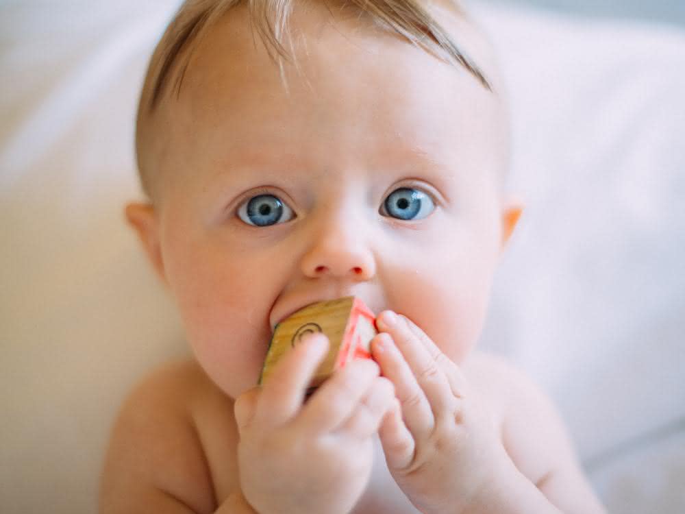 Baby lutscht an Spielzeug
