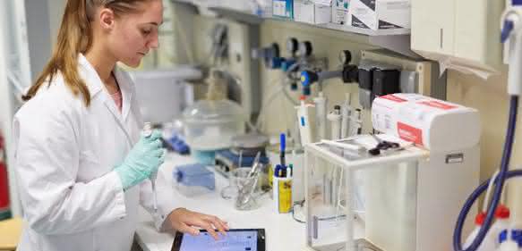 Labormitarbeiterin nutzt Tablet bei der Laborarbeit