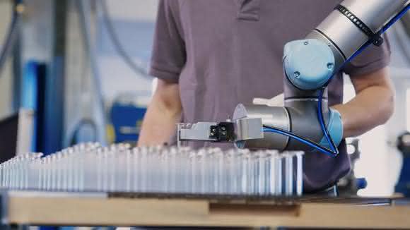 The collaborative robot feeds highly sensitive glass tubes into a forming machine.  (Pictures: Hofmann)