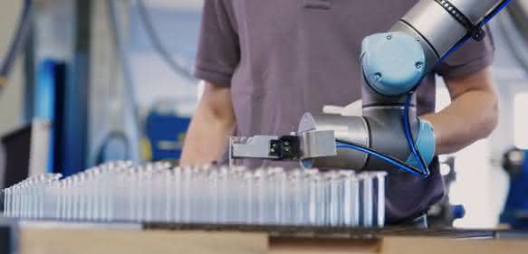 The collaborative robot feeds highly sensitive glass tubes into a forming machine.  (Pictures: Hofmann)