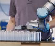 The collaborative robot feeds highly sensitive glass tubes into a forming machine.  (Pictures: Hofmann)