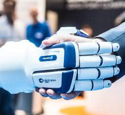Roboter gibt Mensch die Hand