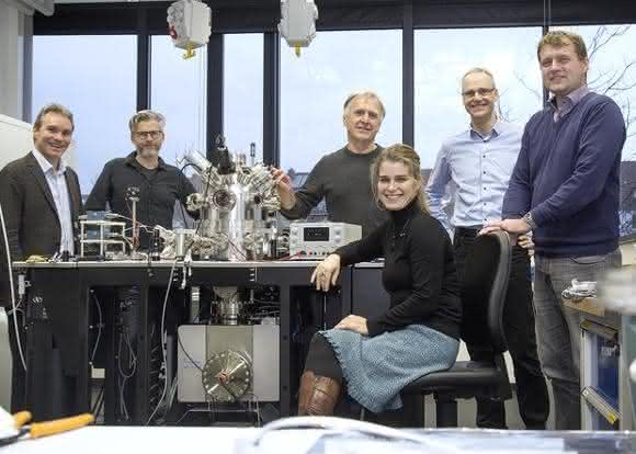Konsortiumsmitglieder stehen um neues Elektronenmikroskop herum