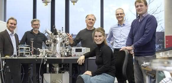 Konsortiumsmitglieder stehen um neues Elektronenmikroskop herum