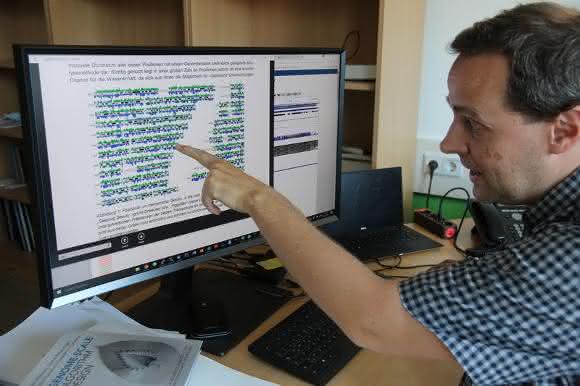 Wissenschaftler zeigt Bildschirmdarstellung einer Genomanalyse