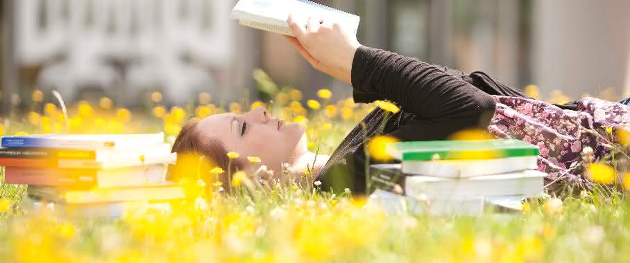 Junge Frau mit Buch in der Sonne