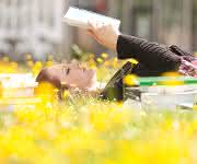 Junge Frau mit Buch in der Sonne Junge Frau mit Buch in der Sonne