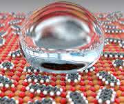 Die Oxide der seltenen Erden (rot/orange) reagieren mit Kohlenwasserstoffen aus der Luft zu Carbonaten und Hydroxiden (grau/weiss). Die Oberfläche wird dadurch wasserabweisend. (Bild: Universität Basel, Departement Physik)