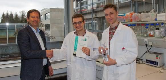 Dr. Wolfgang Kuster (links) gratuliert den Jungforschern. Den Preis nahmen Johann Liebeton und Leon Werner (rechts) in ihrem Labor entgegen.