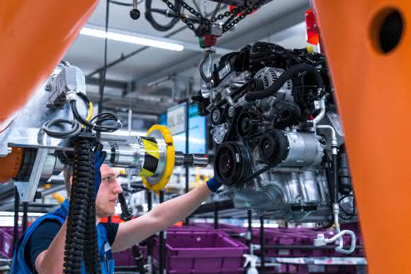 Mitarbeiter führt Industrieroboter im BMW Group Werk Regensburg