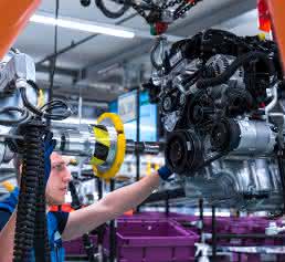 Mitarbeiter führt Industrieroboter im BMW Group Werk Regensburg