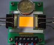 Orange leuchtende OLED auf einer Graphen-Elektrode. Die Zwei-Euro-Münze dient als Größenvergleich. (© Foto Fraunhofer FEP)