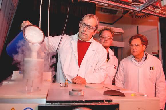 Das Forscherteam Carsten Kötting, Daniel Mann und Klaus Gerwert (von links) bereitet das Messgerät vor. Der Detektor des Spektrometers muss mit flüssigem Stickstoff gekühlt werden.  (© RUB, Marquard)