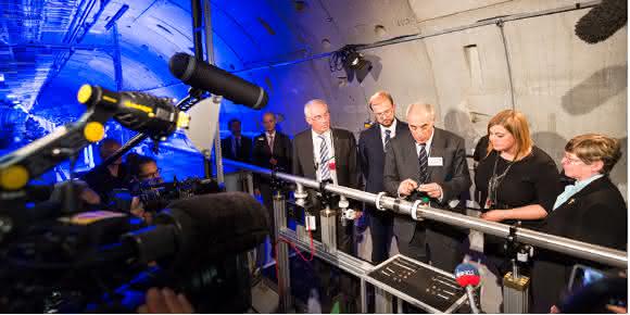 Katharina Fegebank, Hamburgs Zweite Bürgermeisterin und Senatorin für Wissenschaft, Forschung und Gleichstellung, und der polnische stellvertretende Minister für Wissenschaft und Bildung Dr. Piotr Dardziński, fixieren gemeinsam mit European XFEL-Geschäftsführer Prof. Massimo Altarelli ein rund zwei Meter langes Strahlrohr und machen die Anlage bereit für den Beginn der Inbetriebnahme. (Foto: European XFEL)