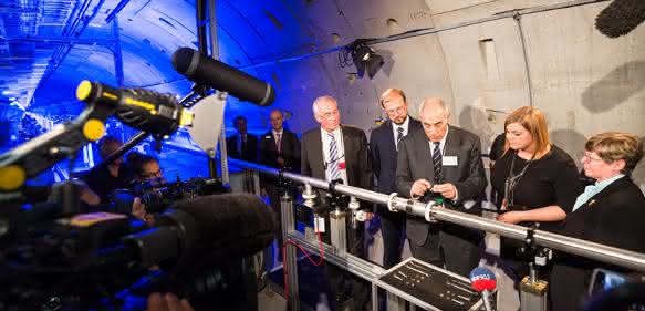 Katharina Fegebank, Hamburgs Zweite Bürgermeisterin und Senatorin für Wissenschaft, Forschung und Gleichstellung, und der polnische stellvertretende Minister für Wissenschaft und Bildung Dr. Piotr Dardziński, fixieren gemeinsam mit European XFEL-Geschäftsführer Prof. Massimo Altarelli ein rund zwei Meter langes Strahlrohr und machen die Anlage bereit für den Beginn der Inbetriebnahme. (Foto: European XFEL)