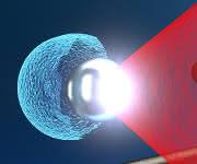 Der Texas Petawatt Laser Puls (rot) wird auf eine schwebende Mikrokugel fokussiert. Die enorme Lichtintensität verursacht die Explosion der Mikrokugel, wodurch potenziell vielseitig nutzbare energetische Ionen (blau) aus einer sehr kleinen Quelle erzeugt werden können. (Bild: Tobias Ostermayr) Der Texas Petawatt Laser Puls (rot) wird auf eine schwebende Mikrokugel fokussiert. Die enorme Lichtintensität verursacht die Explosion der Mikrokugel, wodurch potenziell vielseitig nutzbare energetische Ionen (blau) aus einer sehr kleinen Quelle erzeugt werden können. (Bild: Tobias Ostermayr)