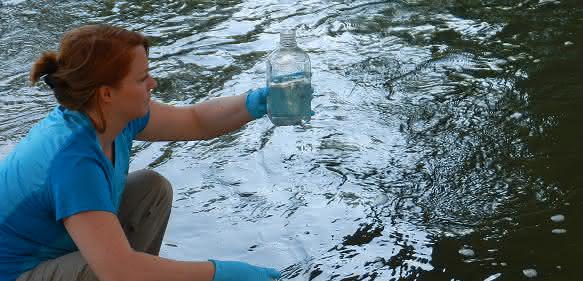 Umweltbiologin Kristy Deiner entnimmt Wasser, um die Umwelt-DNA extrahieren zu können. (Bild UZH)