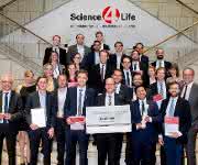Science4Life Venture Cup 2016: Die Gewinner mit den Schirmherren der Gründerinitiative, dem Hessischen Wirtschaftsminister Tarek Al-Wazir (links) und Prof. Dr. Jochen Maas, Geschäftsführer Forschung und Entwicklung der Sanofi-Aventis Deutschland GmbH (rechts).