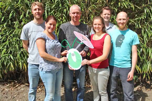 Die beteiligten Wissenschaftler aus Münster mit einem symbolischen Modell ihres Forschungsobjektes - einer Algenzelle mit Sonnenschirm. Von links: Philipp Gäbelein, Ana Karina Hochmal, Michael Hippler, Karen Sinzigs, Martin Scholz und Stefan Schulze; Christian Fufezan fehlt auf dem Foto. (Copyright: WWU / AG Hippler)