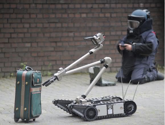 Einsatzkräfte der Polizei entschärfen eine Kofferbombe