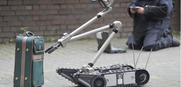 Einsatzkräfte der Polizei entschärfen eine Kofferbombe