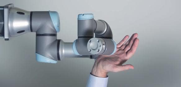 Roboterarm von Universal Robots mit menschlicher Hand