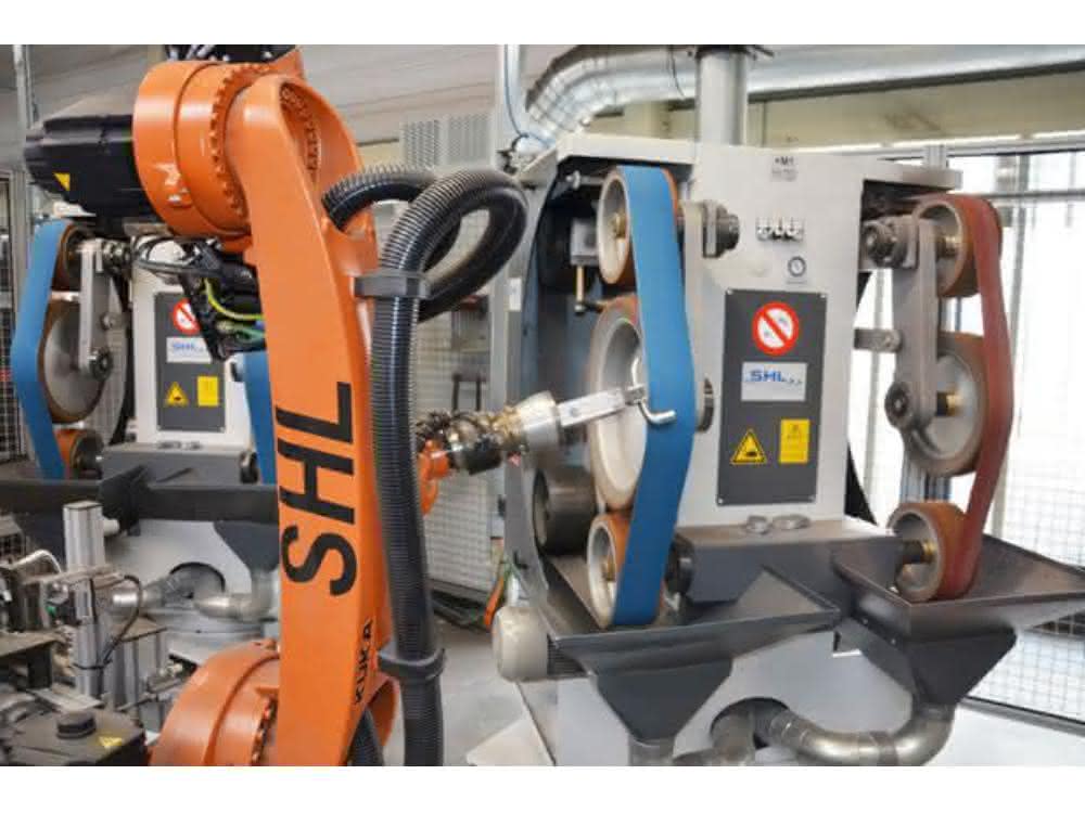 The robot guides the workpieces to the double free belt and contact roller grinding machine for processing