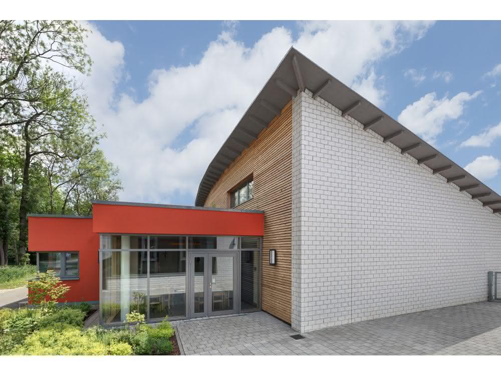 Fassadenbekleidung aus weißen Kalksandsteinverblendern und Lärchenholz