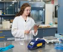 Labormitarbeiterin mit Smartphone und BradyPrinter M611