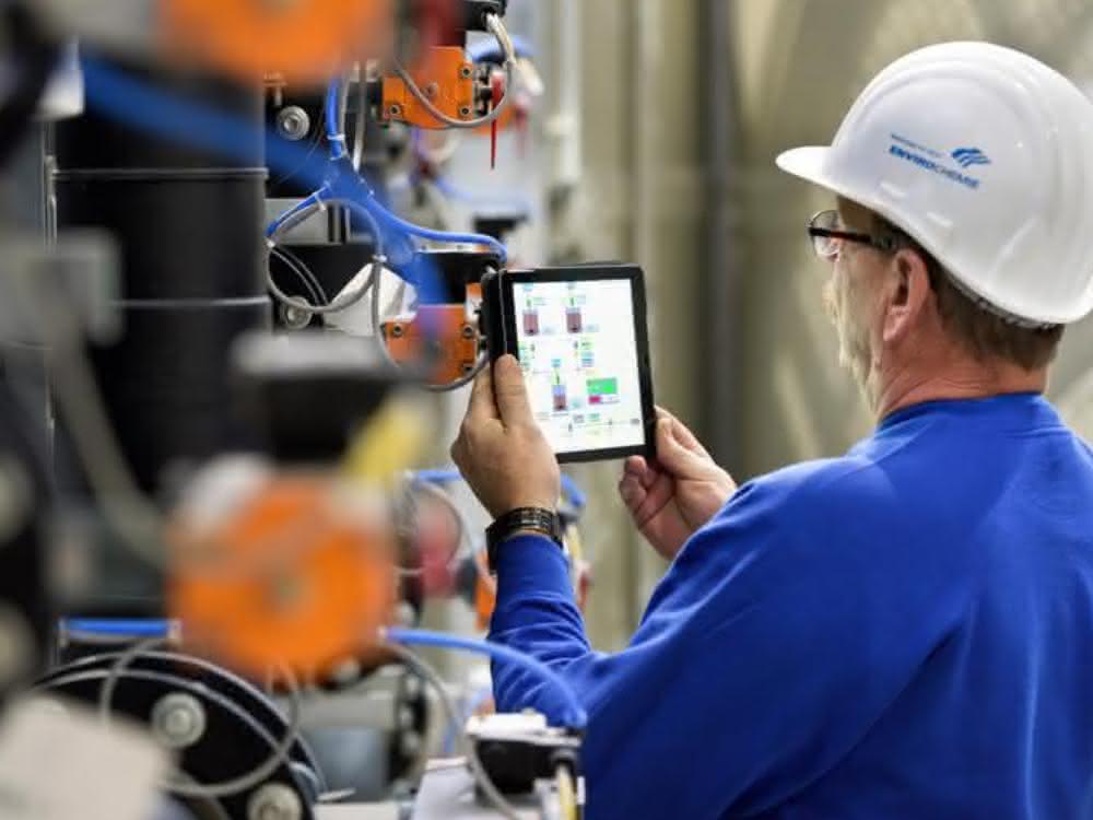 Mann mit Tablett an Wasserversorungssystem