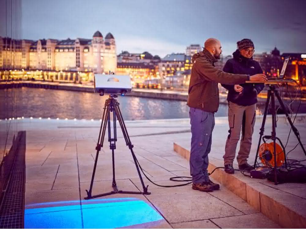 Max Rahrig untersucht mit Kollegin Anna Luib eine Testfläche am Opernhaus in Oslo.