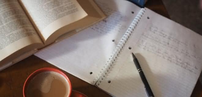 Schreibtisch mit Buch und Heft