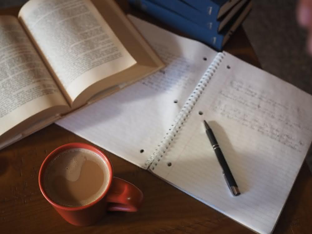 Schreibtisch mit Buch und Heft