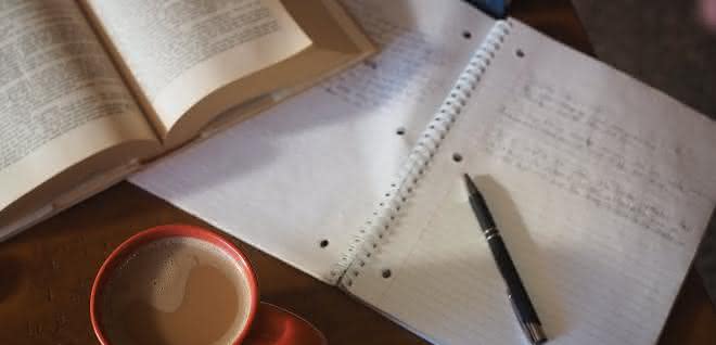 Schreibtisch mit Buch und Heft