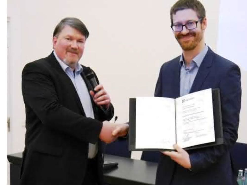 Der Vorsitzende der DECHEMA-Fachgemeinschaft Biotechnologie Prof. Dr. Roland Ulber überreicht den Preis an Jun.-Prof. Dr. Alexander Grünberger.