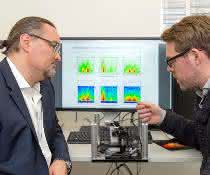Prof. Dr. Juergen Hauer (li) und Erstautor Erling Thyrhaug mit ihrem Messinstrument. Im Hintergrund Spektren, die damit aufgenommen wurden.