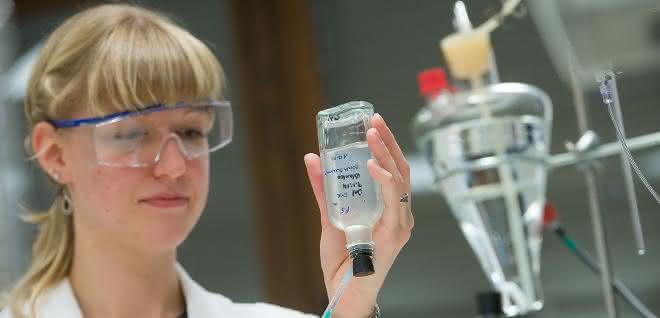 Eine biologisch-technische Assistentin, entnimmt der anaeroben Bakterienkultur eine Probe.