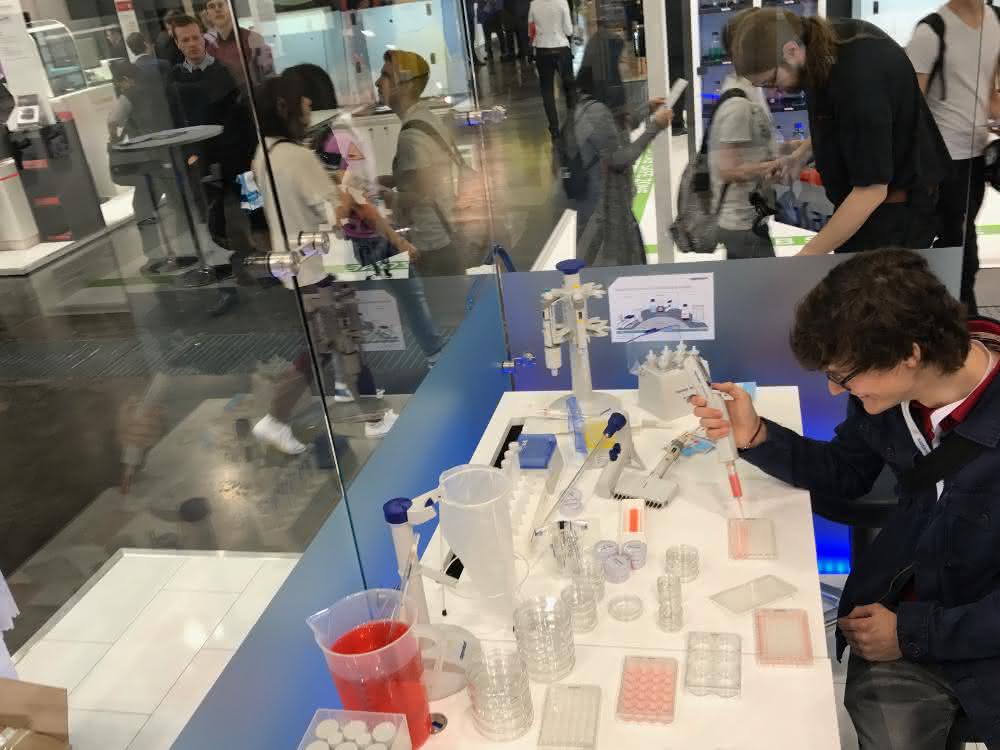 Messebesucher testet Gerätschaften an einem Messestand.