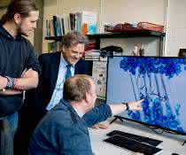 Max Dreier, Klaus Gerwert und Stefan Tenningkeit (von links) betrachten die Darstellung eines Proteins.
