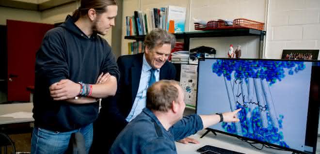 Max Dreier, Klaus Gerwert und Stefan Tenningkeit (von links) betrachten die Darstellung eines Proteins.