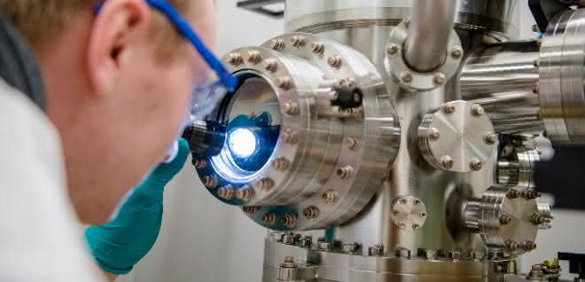 Michael Meischein vor dem Sputter-System, in dem die Nanopartikel durch simultane Beschichtung aus mehreren Quellen in einer ionischen Flüssigkeit erzeugt werden.