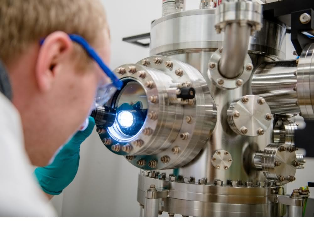 Michael Meischein vor dem Sputter-System, in dem die Nanopartikel durch simultane Beschichtung aus mehreren Quellen in einer ionischen Flüssigkeit erzeugt werden.