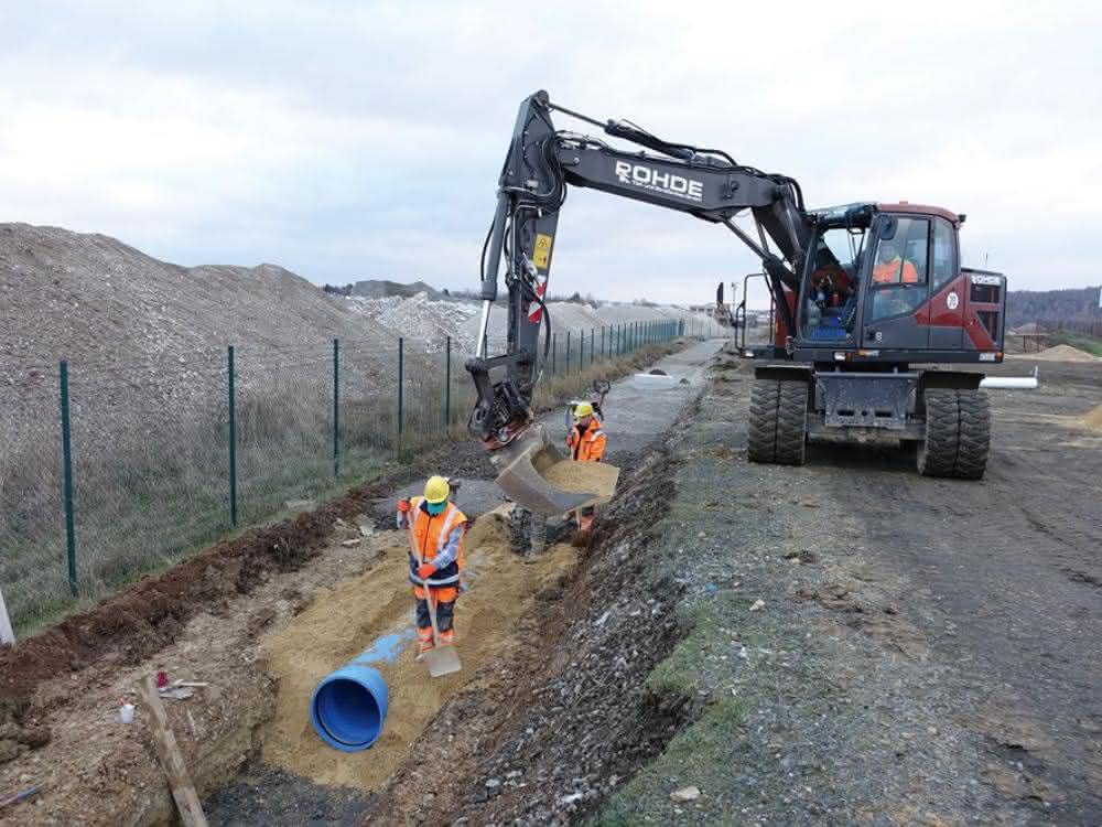 Der Rohrgraben wird mit auf die Baustelle geliefertem Ersatzmaterial verfüllt