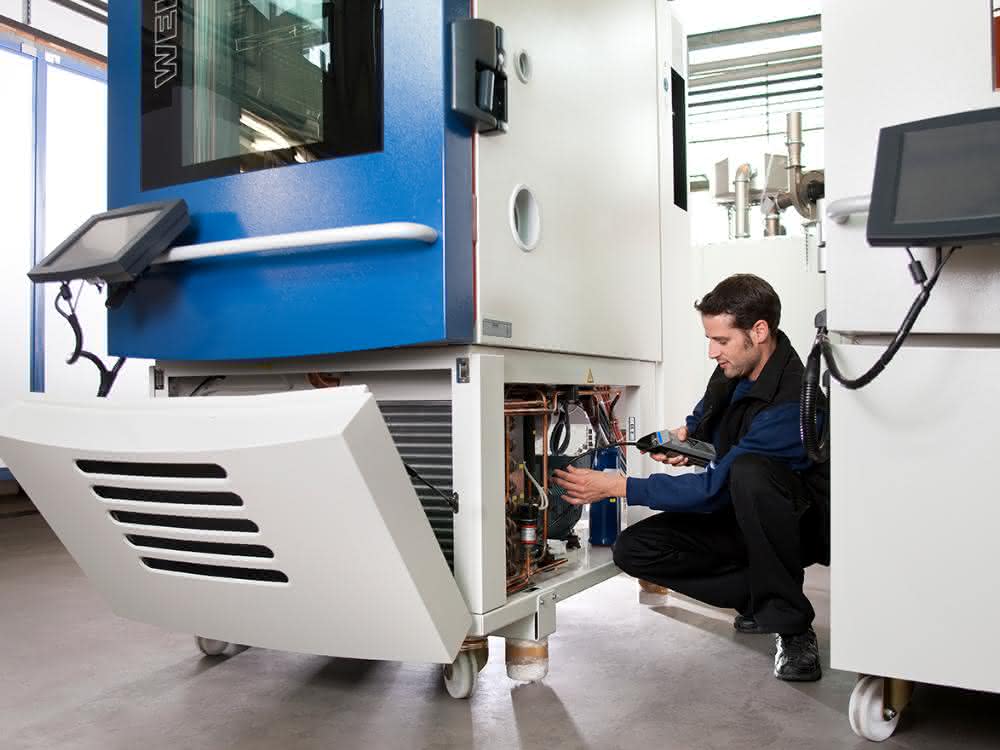 Bei Klimaprüfschränken mit dem Kältemittel WT69 von Weiss Technik kann die Dichtheitsprüfung entfallen. Servicetechniker bei der Leckageprüfung.