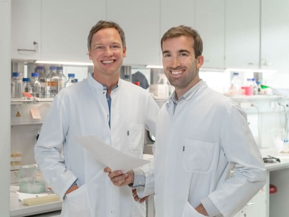 Krebs-Immuntherapien, die auf sogenannte Checkpoint-Inhibitoren setzen, schlagen deutlich besser an, wenn in den Tumorzellen das Protein RIG-I aktiv ist. Das konnten PD Dr. Hendrik Poeck (links) und PD Dr. Simon Heidegger (r.) in einer aktuellen Studie zeigen – ein möglicher Ansatz für zukünftige Therapien. PD Dr. Hendrik Poeck und PD Dr. Simon Heidegger stehen in einem Labor, beide in weißen Kitteln.