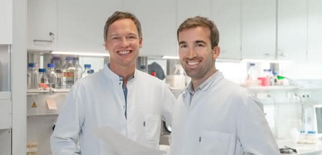 PD Dr. Hendrik Poeck und PD Dr. Simon Heidegger stehen in einem Labor, beide in weißen Kitteln.