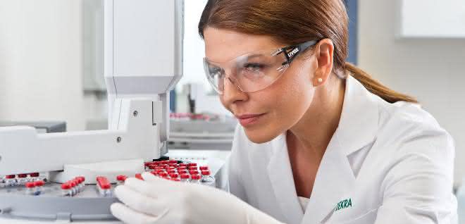 Labormitarbeiterin mit Probenröhrchen im Labor