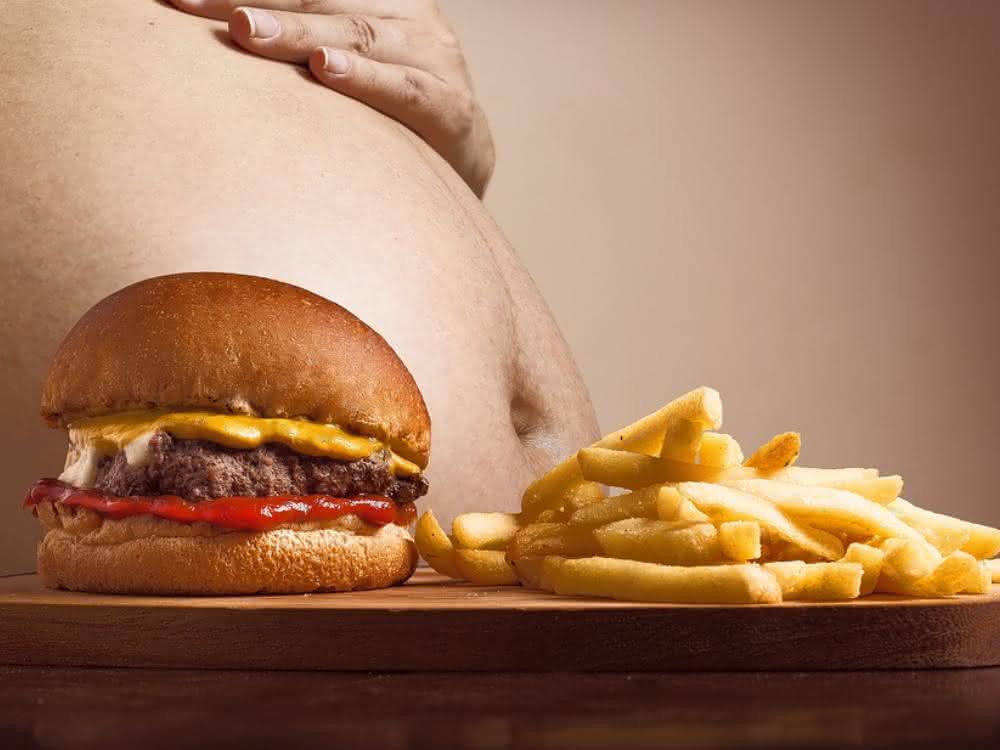 Fettleibiger Mann mit Pommes